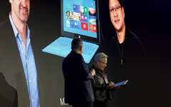 Huang nimmt das Surface RT entgegen: Dahinter ein Foto der Vorstellung aus dem Jahr 2012.