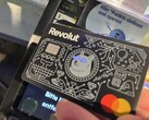 Wir bezahlen mit den leuchtenden Augen der Revolut-Karte an einem EMV-Contactless-Terminal.