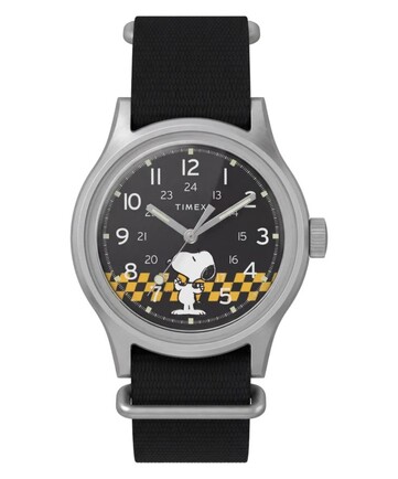 Vorderansicht der Peanuts x Timex MK1 mit schwarzem Zifferblatt, arabischen Ziffern, leuchtenden Zeigern und Indizes sowie einer karierten Snoopy-Grafik.
