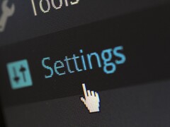Nahaufnahme eines Bildschirms mit dem Menüpunkt Settings und einem Mauszeiger