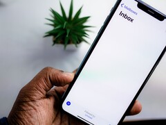 Hand hält ein iPhone mit geöffnetem E-Mail-Posteingang