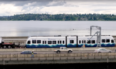 Eine Link-Light-Rail-Garnitur wird von einem Truck über die schwimmende Brücke gedrückt. (Bildquelle: Sound Transit via Youtube)