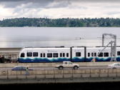 Eine Link-Light-Rail-Garnitur wird von einem Truck über die schwimmende Brücke gedrückt. (Bildquelle: Sound Transit via Youtube)