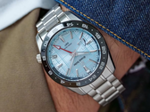 Die neue Grand Seiko SBGE317 besitzt ein eisblaues Zifferblatt mit einem präzisen, sich wiederholenden geometrischen Muster und einer glänzenden, metallischen Oberfläche.
