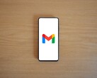 Smartphone mit Gmail-Logo auf einem Holztisch