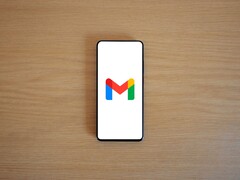 Smartphone mit Gmail-Logo auf einem Holztisch