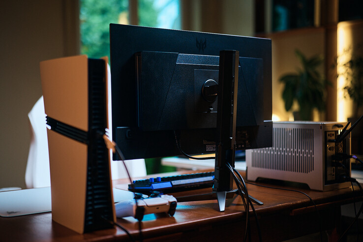 Rückansicht des Acer Predator X27U W3 Monitors auf einem Schreibtisch zwischen PS5 und PC-Gehäuse.