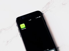 Smartphone auf einem weißen Tisch zeigt die geöffnete WhatsApp-App