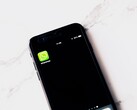 Smartphone auf einem weißen Tisch zeigt die geöffnete WhatsApp-App