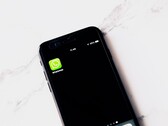Smartphone auf einem weißen Tisch zeigt die geöffnete WhatsApp-App