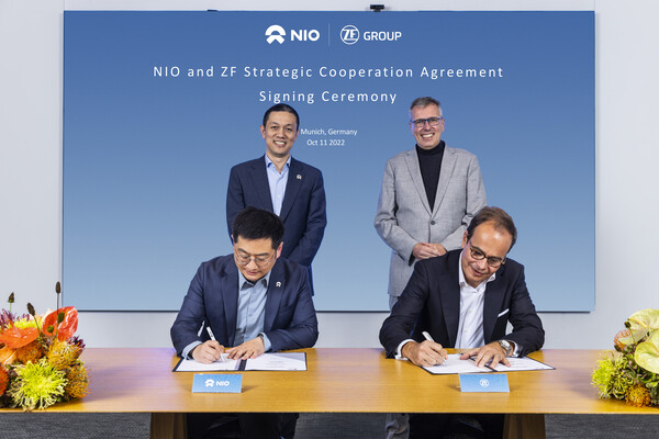 Kooperation von NIO und ZF: Kevin Pan, NIO, (links) und Dr. Peter Holdmann, ZF, (rechts) unterzeichnen die strategische Kooperationsvereinbarung in Anwesenheit von William Li und Dr. Holger Klein.
