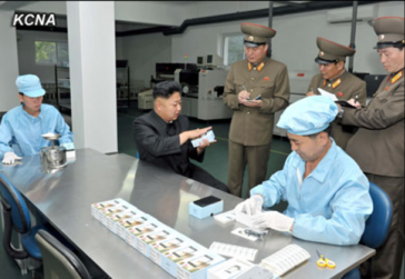 Bei dieser inszenierten "Firmenbesichtigung" schaut sich Kim Jong Un das Arirang-Smartphone an (Foto: KCNA)