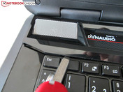 Schritt I: Schrauben mit Tastatursymbol von der Unterseite entfernen (nicht abgebildet). Schritt II: Lautsprecherleiste aus der Verankerung hebeln.