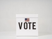 Weiße Wahlurne mit der Aufschrift Vote und einer kleinen US-Flagge
