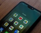 Smartphone auf einem Holztisch mit geöffnetem Google-App-Ordner