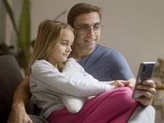 Ein Vater und seine Tochter schauen gemeinsam auf ein Smartphone