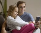 Ein Vater und seine Tochter schauen gemeinsam auf ein Smartphone