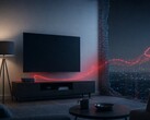Photorealistic 4:3 image of a modern living room with a smart TV and a small streaming box on a media console. Faint glowing red data lines secretly stream out of the devices and through the wall toward the internet, symbolizing a hidden proxy botnet hijacking home devices. Moody cinematic cybersecurity lighting, cool blue room tones with red accents, no people. No text, no logos, no watermark.