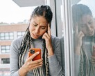 Frau schaut mit ernstem Gesichtsausdruck auf ihr Smartphone
