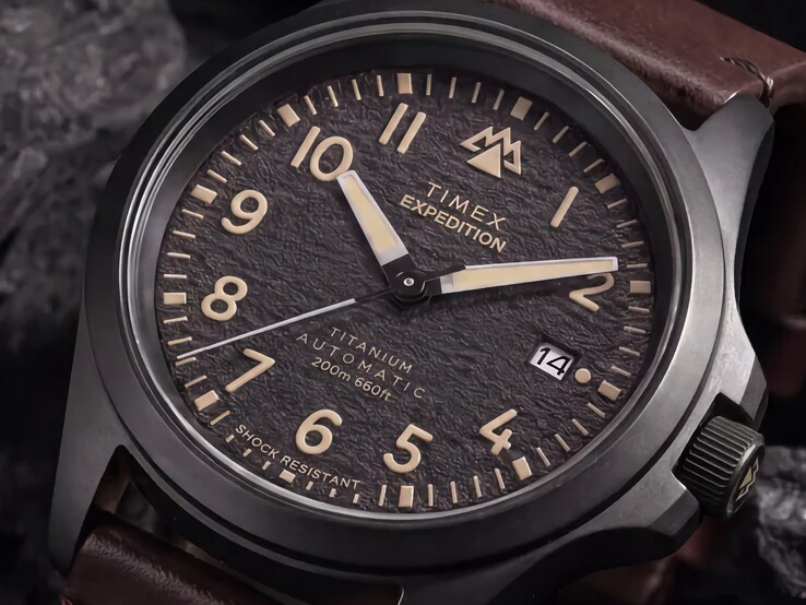 Nahaufnahme des strukturierten schwarzen Zifferblatts der Timex Expedition Field Post Titanium mit arabischen Ziffern, Leuchtzeigern und Datumsfenster